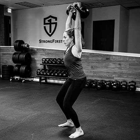 Catherine Buck Le performing the double kettlebell jerk