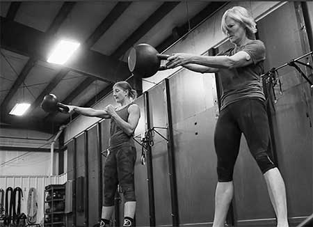 Brianna and Mary Ann performing the Simple & Sinister kettlebell swing