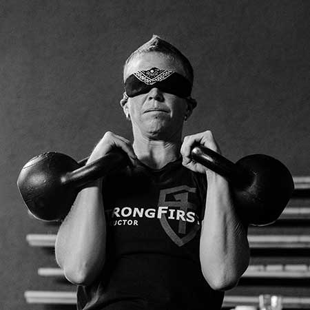 Malou performing a blindfolded double kettlebell rack