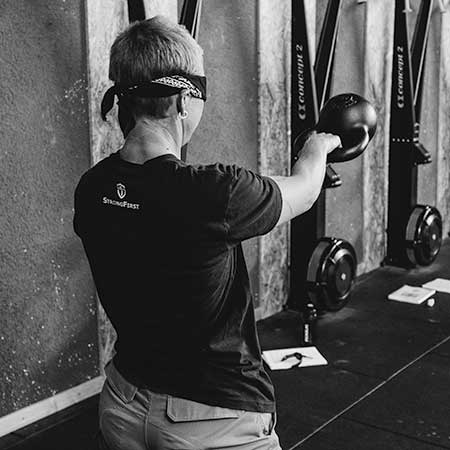 Malou performing a blindfolded one-arm kettlebell swing