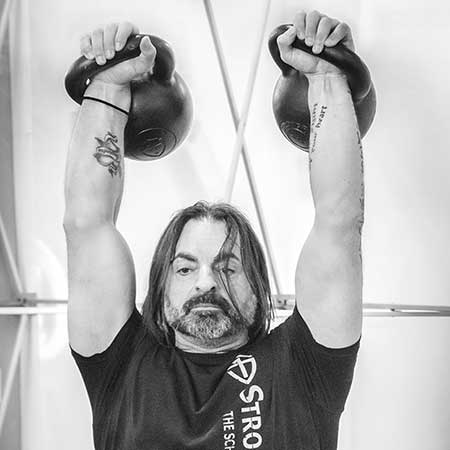 Fabio performing the double kettlebell military press